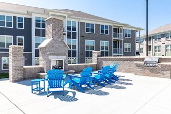 A row of blue chairs are lined up on a patio.